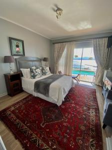 a bedroom with a bed and a large window at 3ColoursBlue Guest House in Mossel Bay