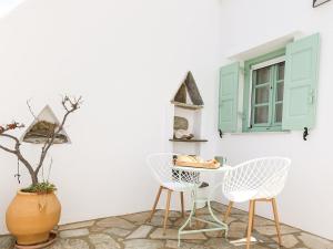 une chambre avec deux chaises, une table et une fenêtre dans l'établissement La Vista TINOS, à Agios Ioannis