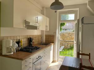 a kitchen with a sink and a stove top oven at CHARMING APARTMENT WITH THE PRIVATE GARDEN in Orsay