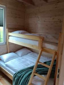 ミエルノにあるR&R Mielno Domki Letniskoweのキャビン内のベッドルーム1室(二段ベッド2組付)