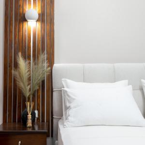 a bedroom with a white bed and a wooden wall at Seaside Guesthouse in Kavála