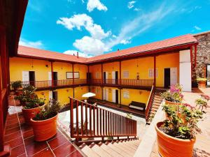 ein Gebäude mit Pflanzen in Töpfen auf einem Balkon in der Unterkunft Hotel Real Del Monte in Mineral del Monte