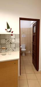 a bathroom with a toilet and a sink and a door at Prywatny pokój w sercu Warszawy in Warsaw