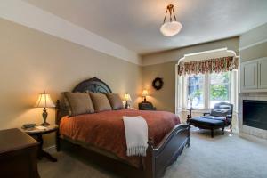 um quarto com uma cama grande e uma lareira em Winchester Inn em Ashland