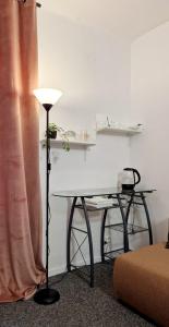 a room with a table and a desk with a lamp at Prywatny pokój w sercu Warszawy in Warsaw