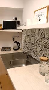 a kitchen with a sink and a microwave at Prywatny pokój w sercu Warszawy in Warsaw