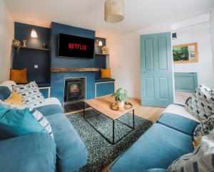 a living room with blue couches and a fireplace at Cosy Hot Tub Getaway Bungalow in Armagh +12 photos