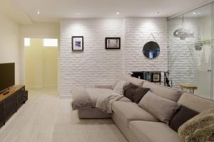 ein Wohnzimmer mit einer Couch und einer Ziegelwand in der Unterkunft 186A Magnífico Apto en La Arena in Gijón