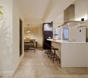 eine Küche mit einer Theke und Hockern in einem Zimmer in der Unterkunft 186A Magnífico Apto en La Arena in Gijón