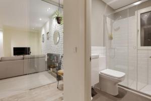 ein weißes Badezimmer mit Toilette und Dusche in der Unterkunft 186A Magnífico Apto en La Arena in Gijón + 30 Fotos