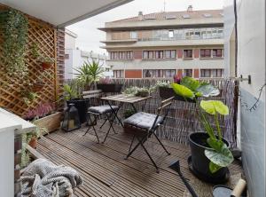 eine Terrasse mit Tisch und Stühlen auf einem Balkon in der Unterkunft 186A Magnífico Apto en La Arena in Gijón