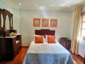 um quarto com uma cama grande e almofadas laranja em Villa María em Ardán