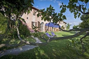 a couple of chairs sitting under an umbrella in a yard at Cascina Rosa B&B in Grazzano Badoglio