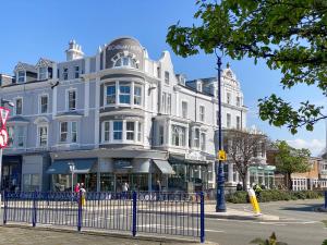 a large white building on the corner of a street at The Broadway Hotel in Llandudno