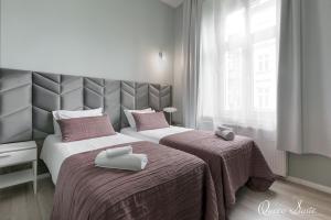 1 dormitorio con 2 camas y toallas. en Platinum Suites, en Cracovia