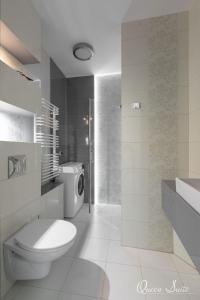 a white bathroom with a toilet and a sink at Platinum Suites in Kraków