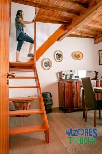 Una mujer está escalando una escalera en una habitación en Atlântida Dream, en Angra do Heroísmo
