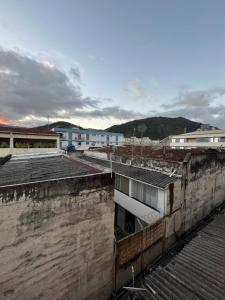 ariale Aussicht auf die Dächer von Gebäuden mit Bergen im Hintergrund in der Unterkunft Apt Central Caraguá in Caraguatatuba