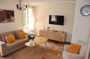 uma sala de estar com um sofá e uma mesa em Le Jas des Parpaillous em LʼIsle-sur-la-Sorgue