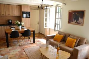 uma sala de estar com um sofá e uma mesa em Le Jas des Parpaillous em LʼIsle-sur-la-Sorgue