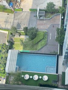 una vista sul tetto di una piscina con ombrelloni di Condo-Wutthakard a Bangkok