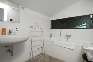 uma casa de banho branca com um lavatório e uma banheira em Cascina Rosa B&B em Grazzano Badoglio