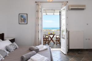 a bedroom with a bed and a view of the ocean at Sea Lilies Suites in Plaka