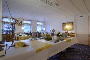 uma grande sala com mesas e cadeiras em Ebsens Hotel em Maribo