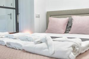 2 lits avec des couvertures blanches et des oreillers roses dans l'établissement Arrábida Luxury Studio, à Vila Nova de Gaia