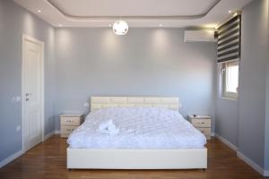 um quarto com uma cama branca num quarto em Durres Luxury Beach Apartment em Durrës