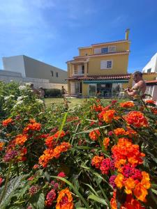 un campo de flores frente a un edificio en Oceans house - Pool, Sauna, 22 Sleeps, 7m to beach en Carcavelos