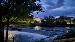 a river with a waterfall in a city at night at Wellness apartment BLACK-WHITE in Široki Brijeg