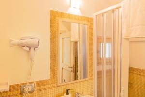 a bathroom with a blow dryer and a mirror at Petralù - Casa Vacanza zona centro in Locorotondo