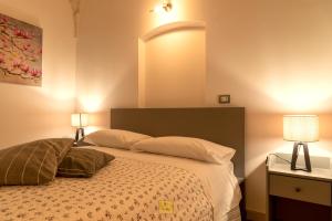 a bedroom with a bed with two lamps on it at Petralù - Casa Vacanza zona centro in Locorotondo
