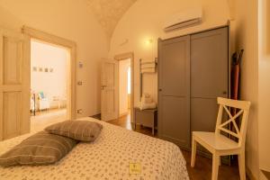 a bedroom with a bed and a chair in a room at Petralù - Casa Vacanza zona centro in Locorotondo