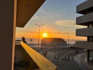 - une vue sur le coucher du soleil depuis le balcon d'un bâtiment dans l'établissement Custódio Ocean View, à Praia de Mira
