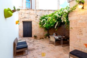 a patio with a table and chairs and flowers at Petralù - Casa Vacanza zona centro in Locorotondo