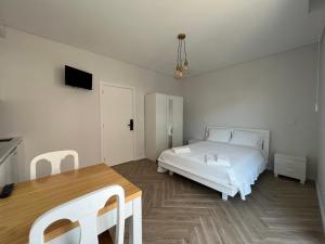 biała sypialnia z łóżkiem i stołem w obiekcie Custódio Ocean View w mieście Praia de Mira