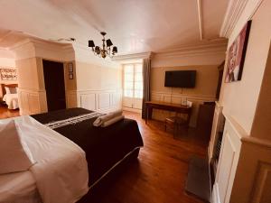 Hotel Real Del Monte في مينيرال ديل مونتي: غرفة نوم بسرير ومكتب وتلفزيون