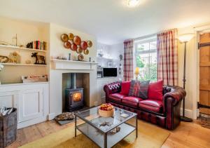 a living room with a red couch and a fireplace at Vine Cottage in Walberswick
