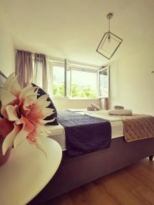 a bedroom with a bed with a flower on it at City Center Apartment Bravos in Makarska