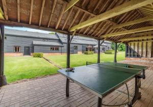 a ping pong table sitting under a pavilion at Sewell Barn Sutton in Sutton