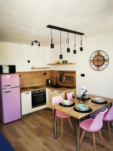 a kitchen with a wooden table and pink appliances at City Center Apartment Bravos in Makarska