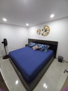 a bedroom with a bed with a blue comforter at HERMOSO APARTAMENTO NUEVO AMOBLADO Conjunto Goya 503 Neiva in Neiva