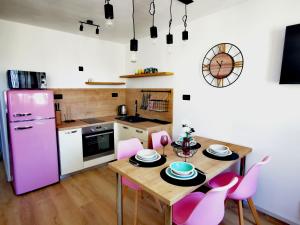 a kitchen with a wooden table and pink appliances at City Center Apartment Bravos in Makarska +46 photos