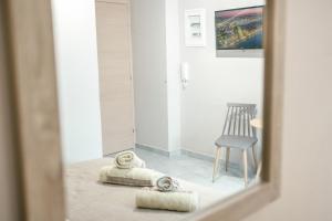 a mirror reflection of a room with a chair and towels at Old Town Elpis Suite in Kos Town