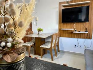 a small dining room with a table and a tv at Hotel APART Zuccolotto 101 in Aracruz