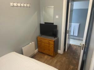a bedroom with a flat screen tv on a dresser at Riverside Lodge in Carlow