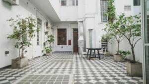 a courtyard with potted trees and a table on a checkered floor at Historical Tango House. Priv area 3 BR /7 guests. in Buenos Aires