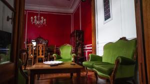a living room with green chairs and a table at Historical Tango House. Priv area 3 BR /7 guests. in Buenos Aires